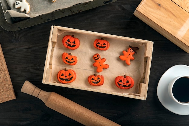 Ingwerplätzchen in Kürbisform für Halloween liegen in einem Holztablett auf dem Tisch Sehr lecker zu einer Tasse Kaffee