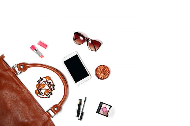 Inhalt der weiblichen Handtasche - Sonnenbrille, Make-up-Artikel, Smartphone, Schmuck