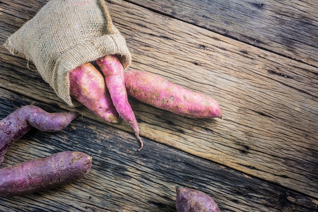 Foto inhame em uma mesa de madeira. batata-doce é um vegetal comumente consumido amplamente na ásia.