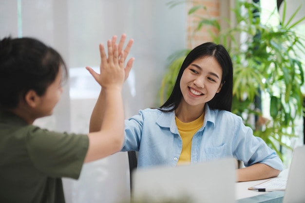 Inicialização feliz trabalho em equipe de negócios asiáticos comemorando o sucesso dos negócios trabalhando juntos