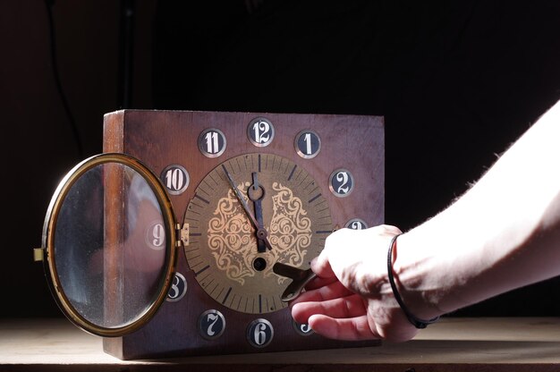 Foto inicio de la hora con una llave clave del reloj en la mano hacer la hora mano y llave para el enrollamiento del reloj vista frontal