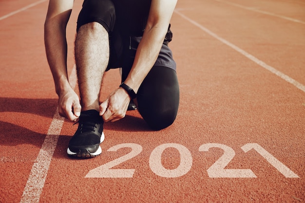 Inicio de los planes de año nuevo Inicio del hombre corriendo en la cancha con luz del atardecer Concepto de objetivo de éxito