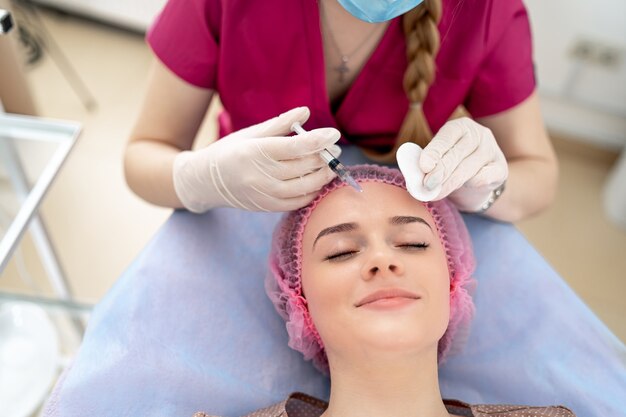 Injeção de vitamina ou botox na testa. Mulher no gabinete de cosmetologia. Conceito de clínica de beleza.