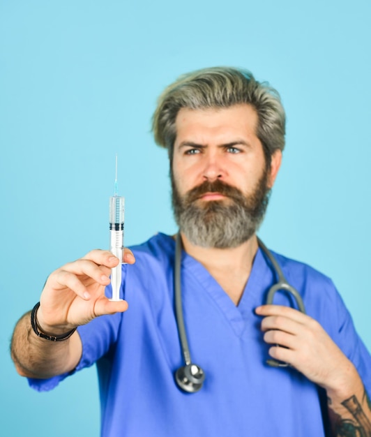 Foto injeção médica desenvolvimento de vacinas inovação vacina contra a gripe antídoto homem enfermeiro com vacina contra coronavírus na seringa médico barbudo usa uniforme uso seringa vacina agulha dose injeção