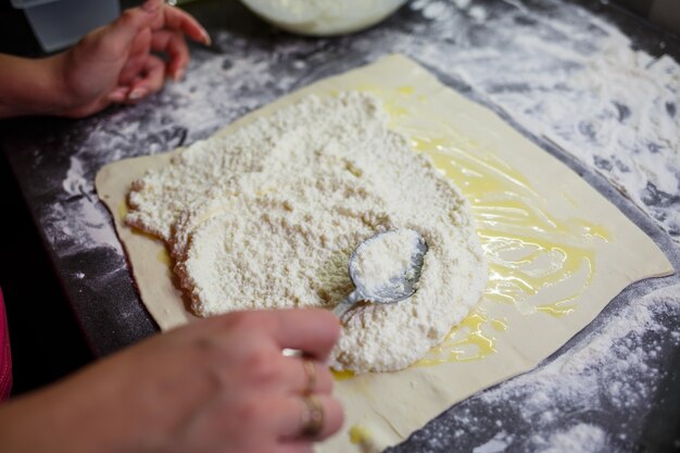 Inländische Brötchen mit Käse backen. Käse auf Teig für Brötchen legen