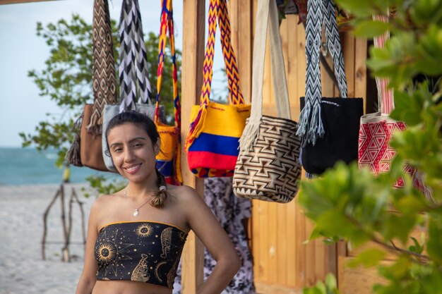 Foto inmersa en el arte colombiano, está rodeada de vibrantes mochilas tejidas.