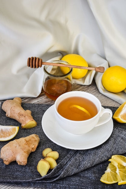 Inmunidad caliente de jengibre que aumenta la vitamina Bebida natural con cítricos, miel e ingredientes en un estilo rústico sobre fondo de madera. Té de camomila. Concepto saludable