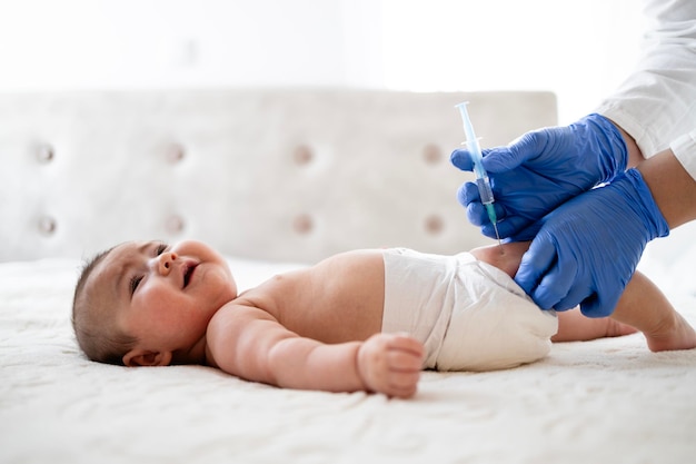 Foto inmunización de los niños el médico le hace una inyección de vacuna al bebé