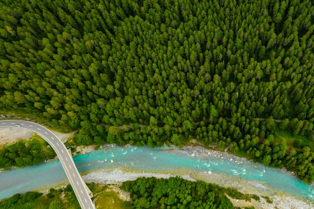 Inn River que fluye en el bosque en Suiza. Vista aérea desde drone en un río azul en las montañas