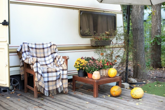 Foto innen außensessel auf holzveranda mit blumentopf und kürbissen im garten zu hause