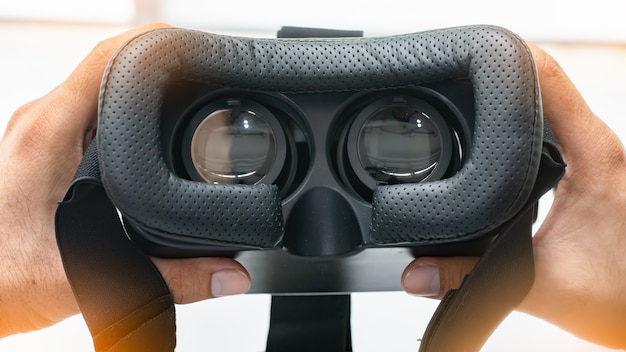 Innen eines Vr- oder ar-Kopfhörers auf Weiß schauen. Hand, die VR-Gläser hält.
