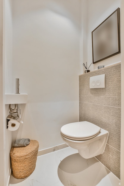 Innenarchitektur der kleinen modernen Toilette mit weißer Toilette in der Ecke und Bild an der Wand
