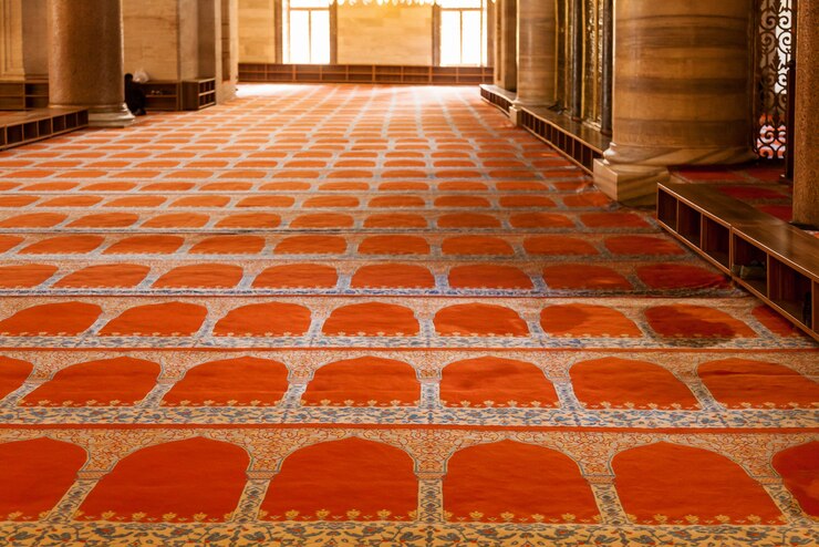 Innenraum der Moschee Teppiche auf dem Boden, Wandmalereien an den Wänden, Trennwände mit Muster