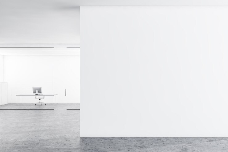 Innenraum des Managerbüros mit weißen Glaswänden, Betonboden, grauem Computertisch mit Stuhl und einer Wandattrappe rechts. 3D-Rendering