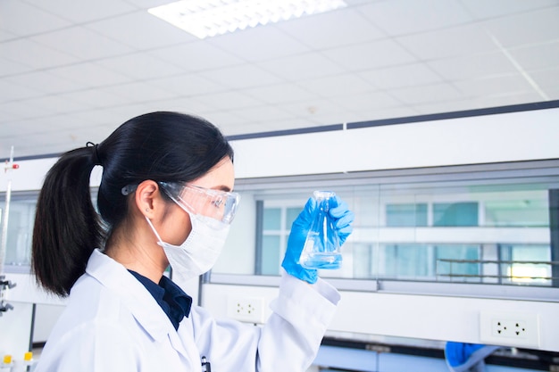 Foto innenraum des sauberen modernen medizinischen oder chemielabors. wissenschaftler, der an einem labor arbeitet. laborkonzept mit asiatischem frauenchemiker.