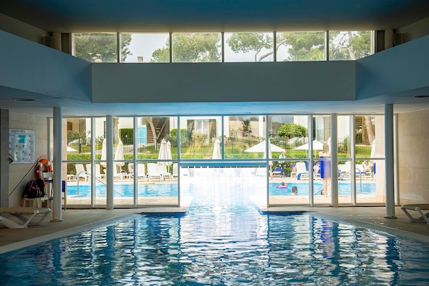 Innenraum des Swimmingpools inmitten von Liegestühlen in einem luxuriösen Resort