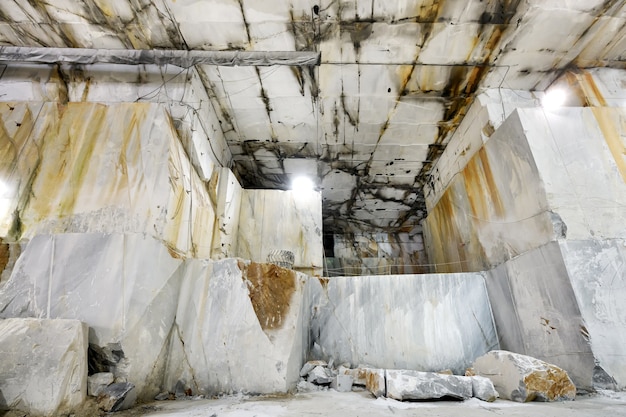 Innerhalb eines Bergschachts in einer Carrara-Marmormine oder einem Steinbruch, die die geschnittenen Steinwände des Felsens in der Toskana, Italien zeigen