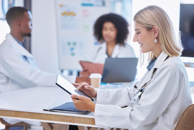 Innovación del trabajo en equipo y médicos que trabajan en tabletas digitales en una reunión o conferencia leyendo e investigando juntos Colaboración de los trabajadores de la salud en la búsqueda en línea de avances o descubrimientos