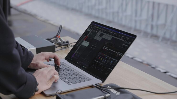 Foto innovadora configuración de producción de música moderna con una computadora portátil junto con un clip de equipo esencial