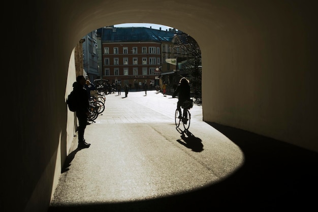 Innsbruck, Áustria, 9 de janeiro de 2020, silhuetas de pessoas e sombras de um ciclista em um túnel com vista para a cidade velha