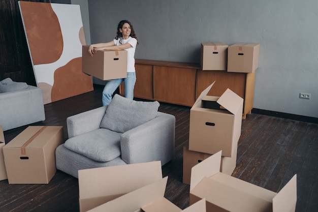 Inquilina feliz sosteniendo una caja con cosas personales en el interior Concepto de vivienda alquilada para el día de la mudanza