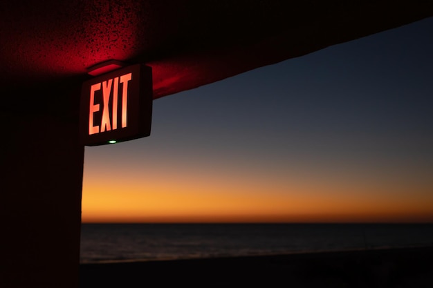 Inschrift Exit auf dem Gebäude an der Küste während des Sonnenuntergangs