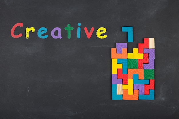 Inscrição de conceito de ideia criativa de negócios e blocos de quebra-cabeça no quadro-negro