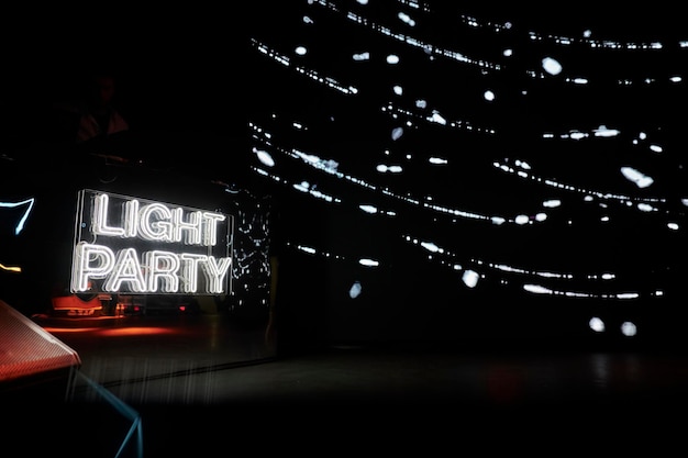 Inscrição de néon LIGHT PARTY na parede