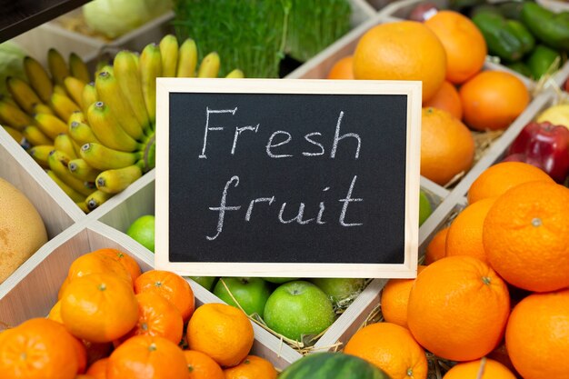 Inscrição em giz de frutas frescas na placa da loja de vegetais