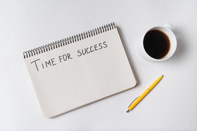 Inscrição motivacional, tempo para o sucesso. Vista superior do caderno, caneta e café.