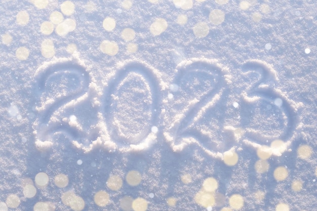 Inscrição na superfície branca da neve feliz conceito de ano novo vista superior acima da luz de desfocagem e do natal