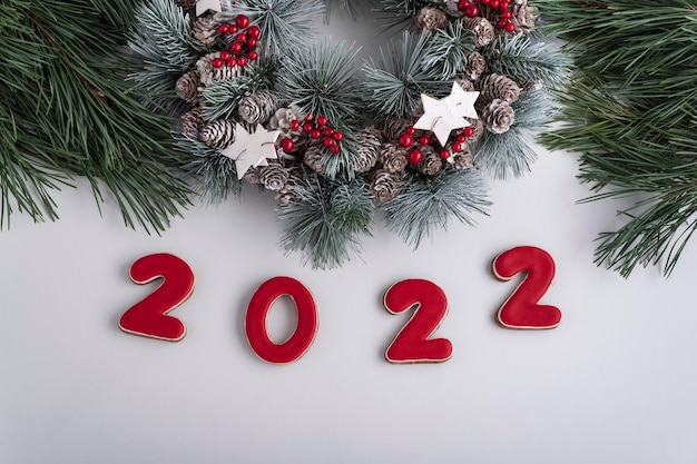 Foto inscripción 2022 y corona de navidad, vista superior. fondo blanco. feliz año nuevo 2022