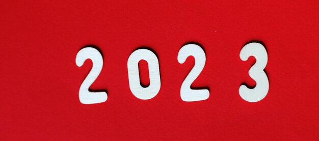 Inscripción 2023 con números de madera sobre fondo rojo Banner de concepto festivo