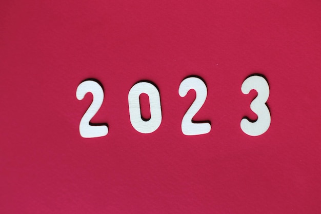 Inscripción 2023 con números de madera sobre fondo rojo Concepto festivo