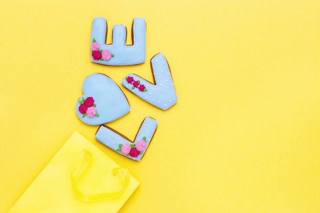 Foto inscripción amor por galletas caseras y paquete amarillo con espacio de copia