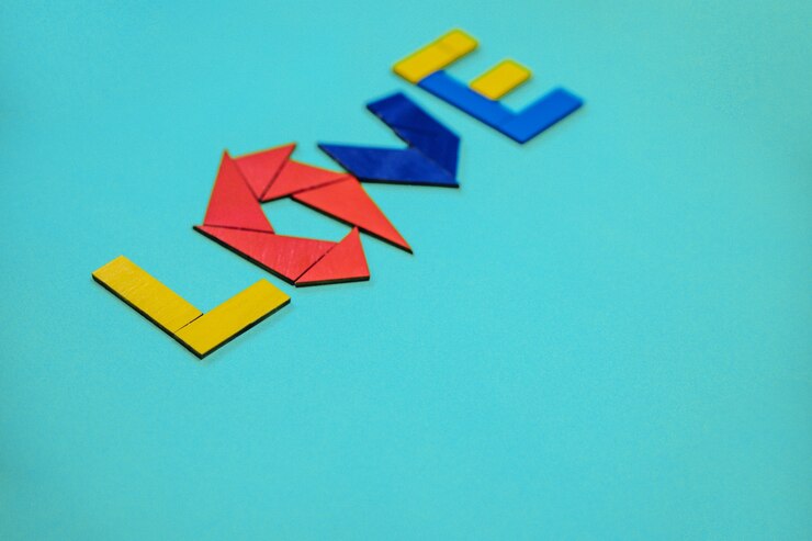 Foto la inscripción amor. letras de colores de formas geométricas de madera. el concepto de san valentín y boda.