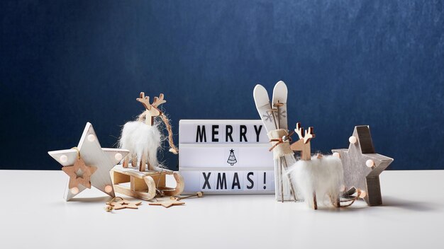 Inscripción de caja de luz Feliz Navidad y adornos de madera.