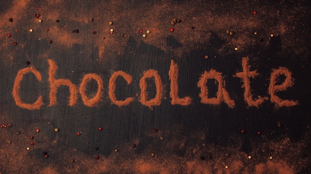 Inscripción de chocolate hecha de cacao en polvo con la adición de trozos de chocolate