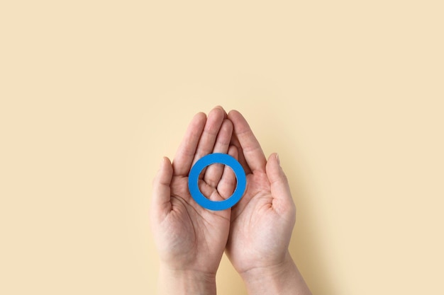 Foto inscripción del día mundial de la diabetes círculo azul en manos de mujer sobre un fondo beige 14 de noviembre