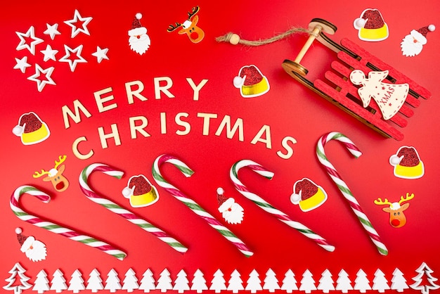 La inscripción Feliz Navidad hecha de letras de madera que se encuentran planas desde arriba aisladas en un rojo