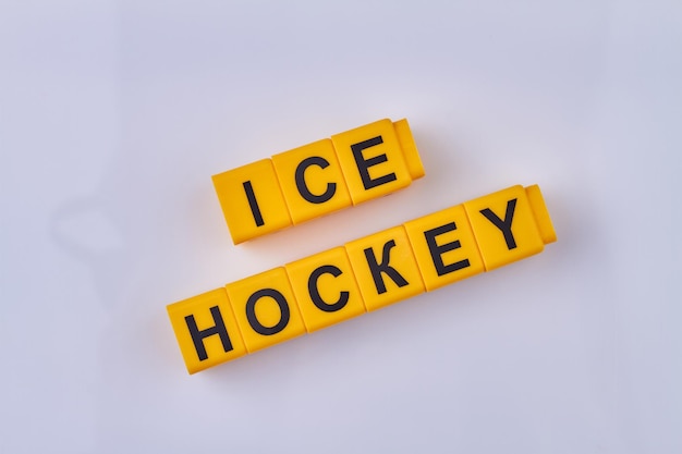 La inscripción hockey sobre hielo escrita en cubos amarillos aislados en el concepto de deporte de invierno de fondo blanco