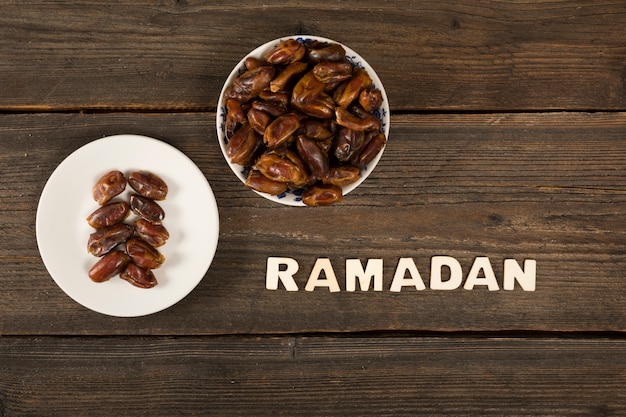 Foto inscripción de ramadán con dátiles de frutas en mesa