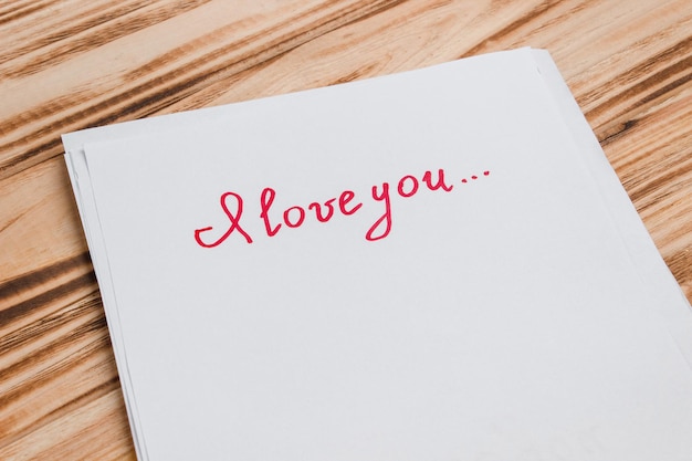 La inscripción te amo en papel. El concepto de San Valentín, declaraciones de amor, relaciones.