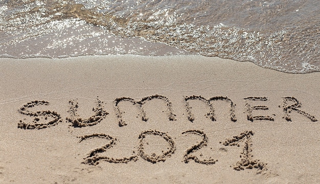 Inscripción de texto en la playa de arena verano 2021