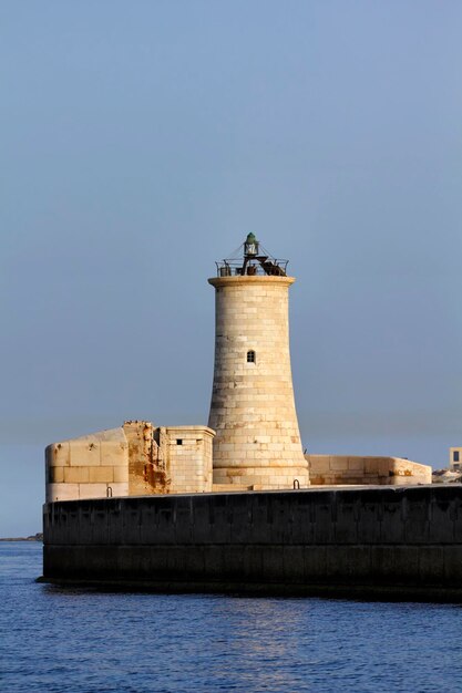 Foto insel malta, leuchtturm am eingang des hafens von valletta