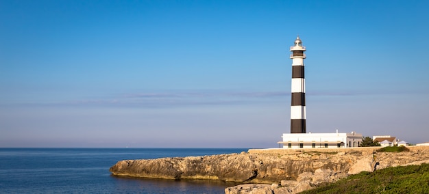 INSEL MINORCA - SPANIEN - CIRCA AUGUST 2020: malerischer Leuchtturm von Artrutx bei Sonnenuntergang, berühmtes Wahrzeichen der Insel