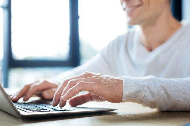 Inserindo dados. Close de uma mão masculina digitando no teclado enquanto insere dados importantes