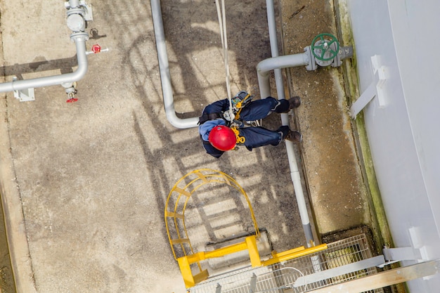 Inspección de seguridad de altura de acceso por cuerda de trabajador masculino de la industria de tanques de gas y petróleo de almacenamiento de espesor
