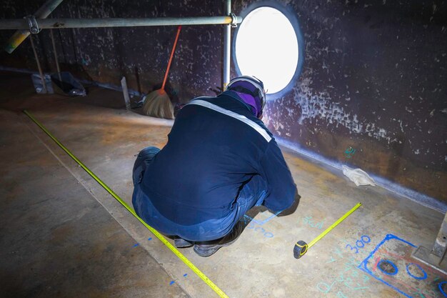 Inspección del trabajador masculino tanque de escaneo de piso flotante externo de pared de óxido que pierde la placa inferior de espesor en el tanque de alcantarilla