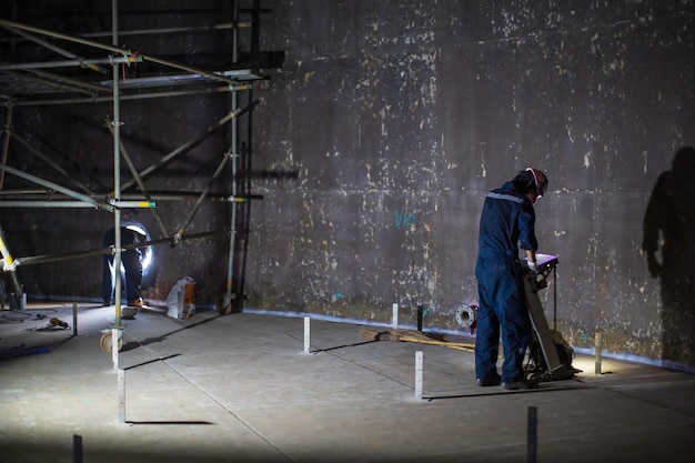 Inspección del trabajador masculino tanque de escaneo de piso flotante externo de pared de óxido que pierde la placa inferior de espesor en el tanque de alcantarilla